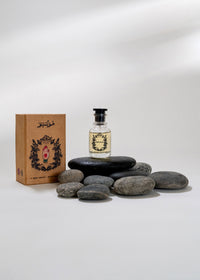 Bottle of perfume, box, and stones on a white background