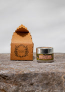 Firaaqh wax perfume product packaging on a stone surface with a neutral background