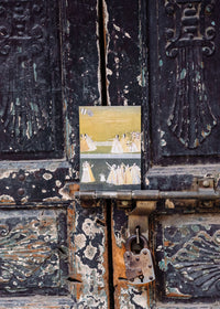 Vintage metal door with peeling paint and a small painting attached, featuring a landscape scene.